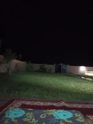 a yard at night with a rangoli in the grass at Villa 30 km a Marrakech in Marrakech