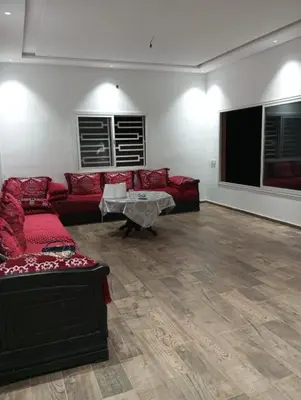 a living room with red couches and a flat screen tv at Villa 30 km a Marrakech in Marrakech