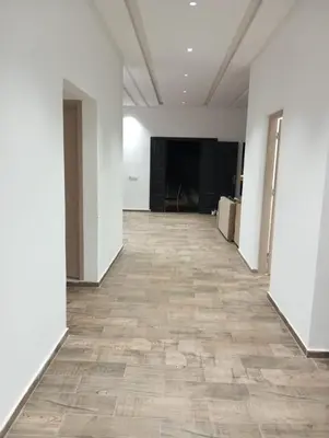 an empty hallway with white walls and wood floors at Villa 30 km a Marrakech in Marrakech