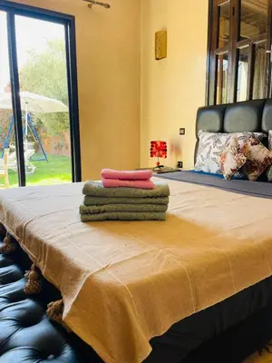 a bed with three towels sitting on top of it at Villa MsHolidays Victoria privatisée Marrakech in Marrakech