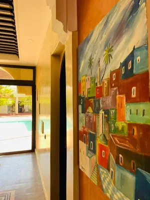 a painting of buildings on a wall in a hallway at Villa MsHolidays Victoria privatisée Marrakech in Marrakech
