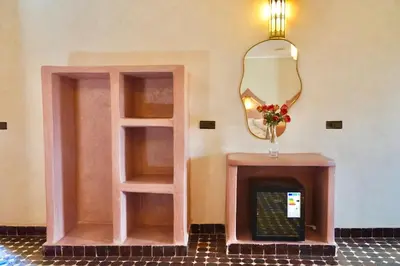 a room with a fireplace and a mirror at Hotel Sunset Palace in Merzouga