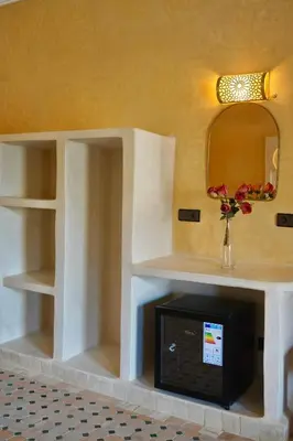 a living room with a fireplace and a mirror at Hotel Sunset Palace in Merzouga