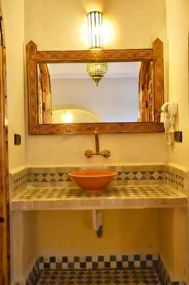 a bathroom with a bowl sink and a mirror at Hotel Sunset Palace in Merzouga