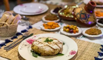 a table with a plate of food on a table at Riad Tafoukt Palace in Fès