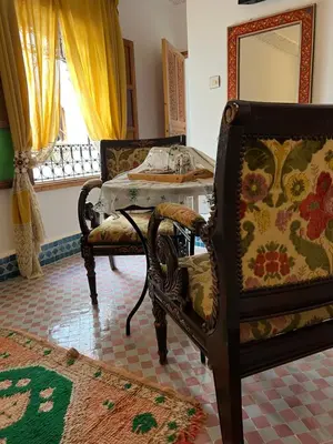 a living room with a chair and a table at Riad Tafoukt Palace in Fès