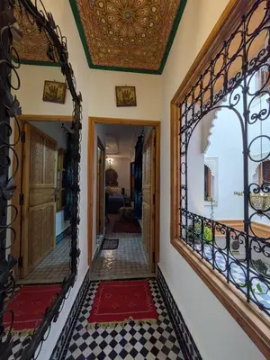 a hallway with a mirror and a tile floor at Riad Tafoukt Palace in Fès