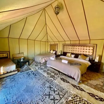 a room with two beds in a tent at Sahara Luxury Glamping in Merzouga