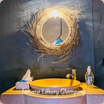 a bathroom with a yellow sink and a mirror at Sahara Luxury Glamping in Merzouga