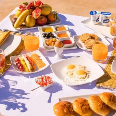 a table with plates of breakfast foods and drinks at Sahara Luxury Glamping in Merzouga