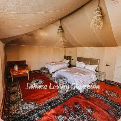 a bedroom with two beds in a tent at Sahara Luxury Glamping in Merzouga