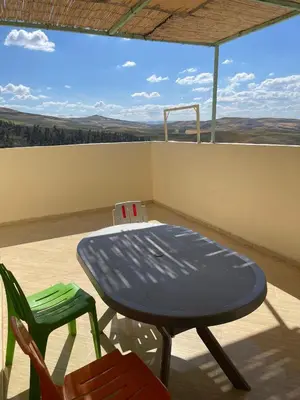 a blue table and chairs on a balcony with a view at اقامة قرب حمام my yaacup in Moulay Yacoub