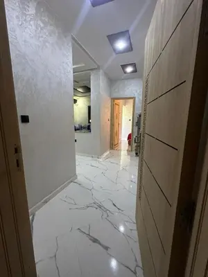 a hallway with a white tile floor and a door at اقامة قرب حمام my yaacup in Moulay Yacoub