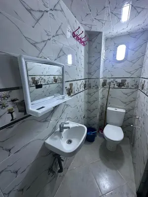 a bathroom with a sink and a toilet and a mirror at اقامة قرب حمام my yaacup in Moulay Yacoub