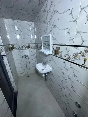 a white bathroom with a sink and a mirror at اقامة قرب حمام my yaacup in Moulay Yacoub