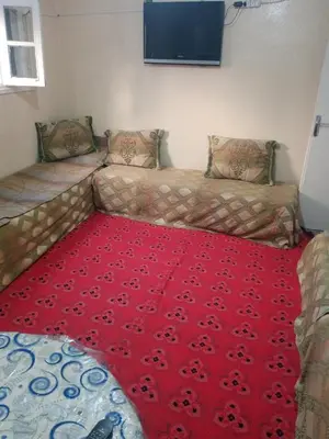 a living room with two couches and a red carpet at Appartement au centre ville in Beni Mellal