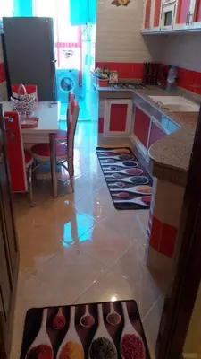 a kitchen with a counter and a table with vases on the floor at Furniture apartment in Meknès