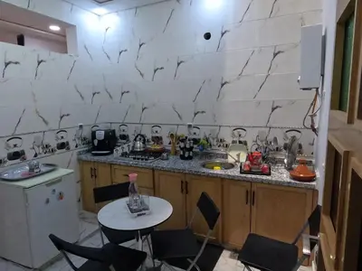 a kitchen with a counter and a table with chairs at Tislite d azrou in Azrou