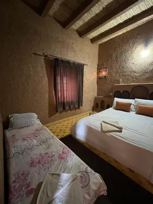 a hotel room with two beds and a window at Auberge Camping Tafraoute Montagnes in Tafraoute Sidi Ali