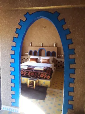 a bedroom with a bed in a blue archway at Auberge Camping Tafraoute Montagnes in Tafraoute Sidi Ali