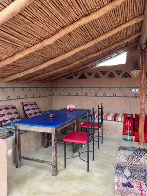 a blue table with red chairs in a room at Auberge Camping Tafraoute Montagnes in Tafraoute Sidi Ali
