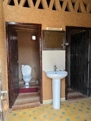 a bathroom with a sink and a toilet at Auberge Camping Tafraoute Montagnes in Tafraoute Sidi Ali