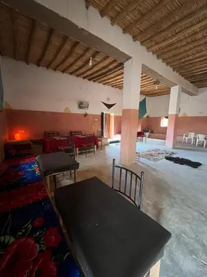 a room with a table and chairs in a building at Auberge Camping Tafraoute Montagnes in Tafraoute Sidi Ali