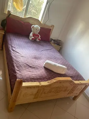 a teddy bear sitting on top of a wooden bed at تازة in Taza