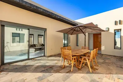 a table and chairs with an umbrella on a patio at Villa Lella, piscine Chauffée, cuisinière in Marrakech
