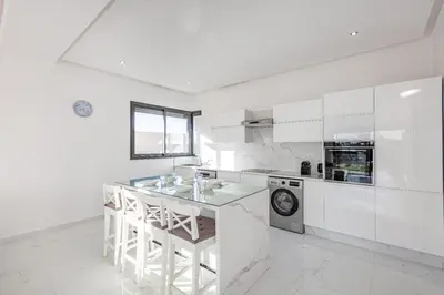 a white kitchen with a counter and a dishwasher at Villa Lella, piscine Chauffée, cuisinière in Marrakech