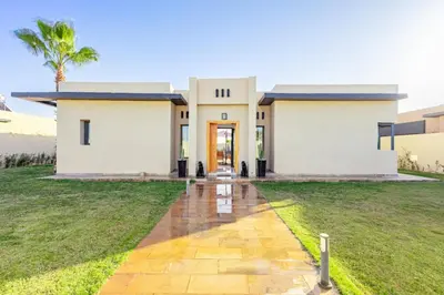 a large white house with a pathway leading to it at Villa Lella, piscine Chauffée, cuisinière in Marrakech