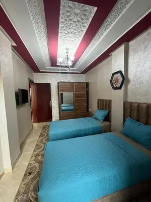 two beds in a room with blue sheets at APPART HOTEL OUED EDDAHAB in Khenifra