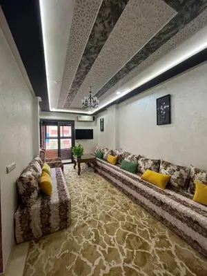a large living room with a long couch and yellow pillows at APPART HOTEL OUED EDDAHAB in Khenifra