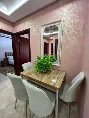 a dining room table with chairs and a mirror at APPART HOTEL OUED EDDAHAB in Khenifra