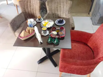 a table with breakfast food on it with a red chair at APPART HOTEL OUED EDDAHAB in Khenifra
