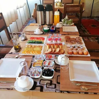 a table with many trays of different types of food at Luxury Sahara Camp in Merzouga