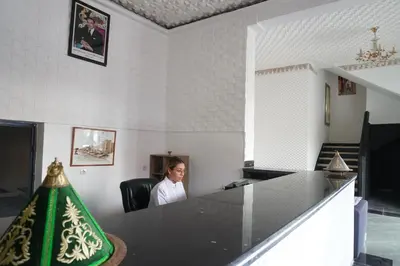 a woman sitting in a chair in a room at Hotel Warda in Ouarzazate