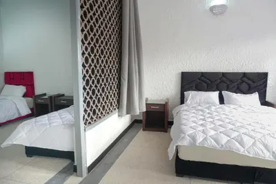 a bedroom with a bed and two night stands at Hotel Warda in Ouarzazate