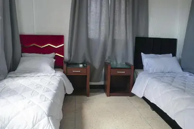 two beds sitting next to each other in a room at Hotel Warda in Ouarzazate