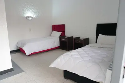 a bedroom with two beds and two night stands at Hotel Warda in Ouarzazate