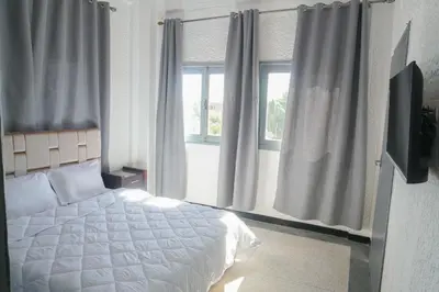 a bedroom with a white bed and a window at Hotel Warda in Ouarzazate