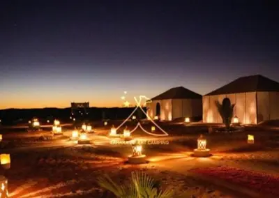 a group of lights in front of a building at night at Merzouga bivouac star in Taouz
