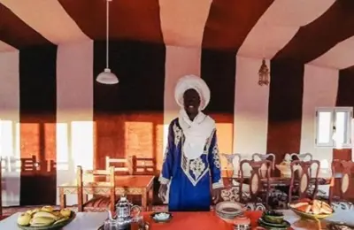 a woman standing in front of a table in a room at Merzouga bivouac star in Taouz