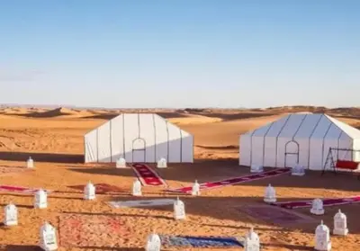 two white domes in the middle of a desert at Merzouga bivouac star in Taouz