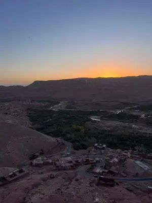an aerial view of a city with the sunset in the background at Kasbah Tigmi El Janoub in Aït Ben Haddou