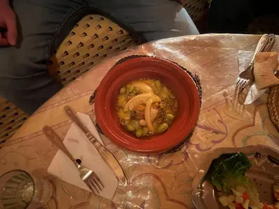 a red bowl of food on a table at Kasbah Tigmi El Janoub in Aït Ben Haddou