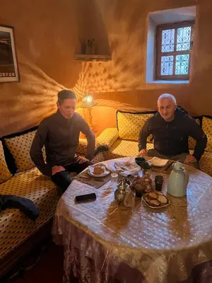 two men sitting at a table in a room at Kasbah Tigmi El Janoub in Aït Ben Haddou