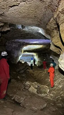 a group of people walking inside of a cave at GITE LA GROTTE VALLEE in Aoûtouss