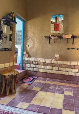 a room with a bench and a table and a window at GITE LA GROTTE VALLEE in Aoûtouss