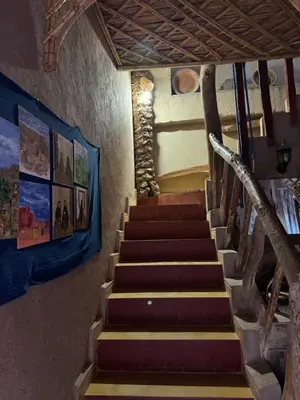 a staircase in a room with paintings on the walls at GITE LA GROTTE VALLEE in Aoûtouss